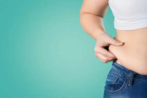 Image of woman pinching her love handles to show weight gain East Tilbury